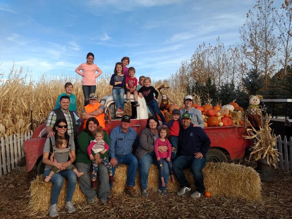 Family enjoying a sunny fall visit at the pumpkin truck